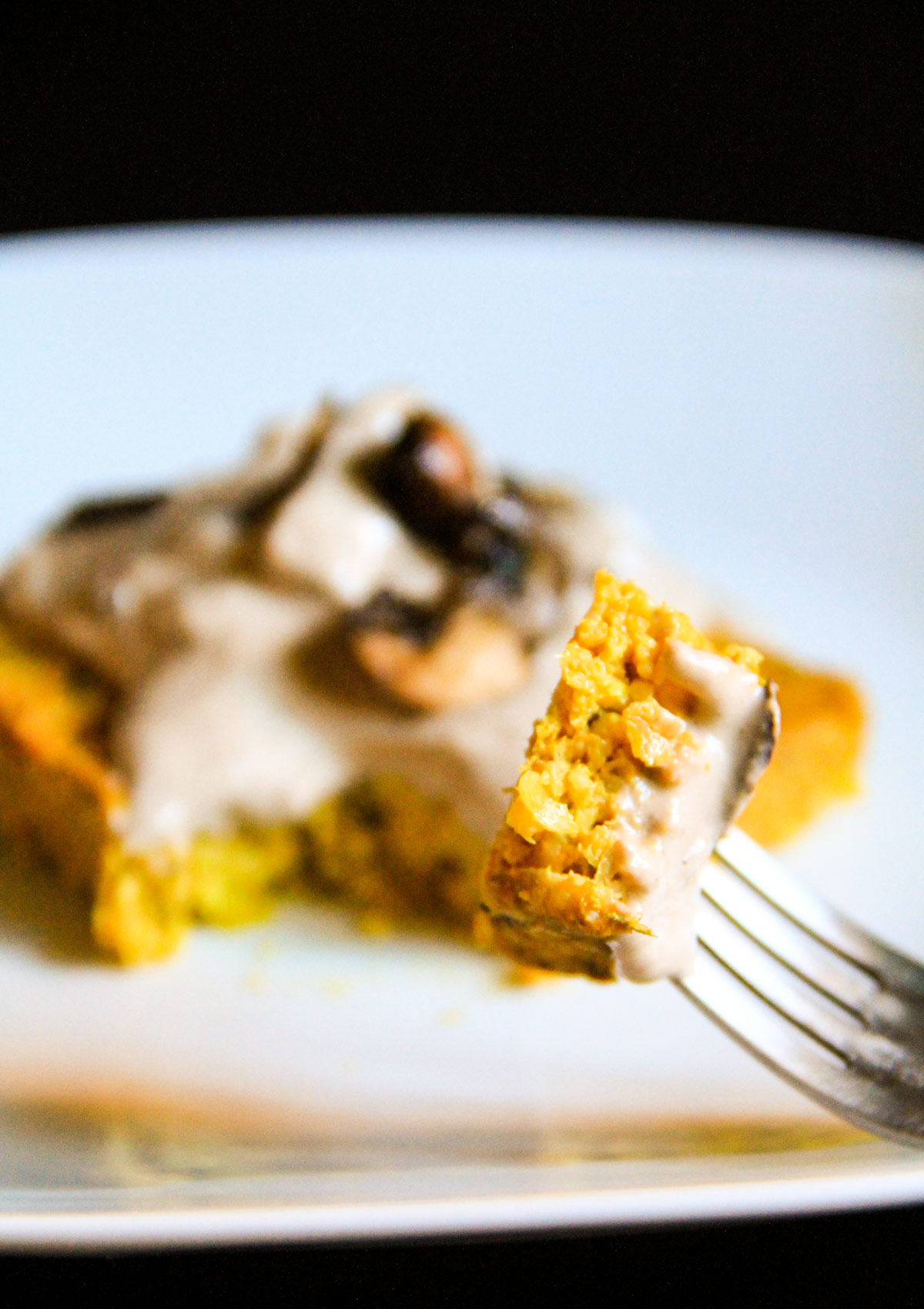 Polenta ai funghi Una forchetta in primo piano che tiene un pezze di polenta