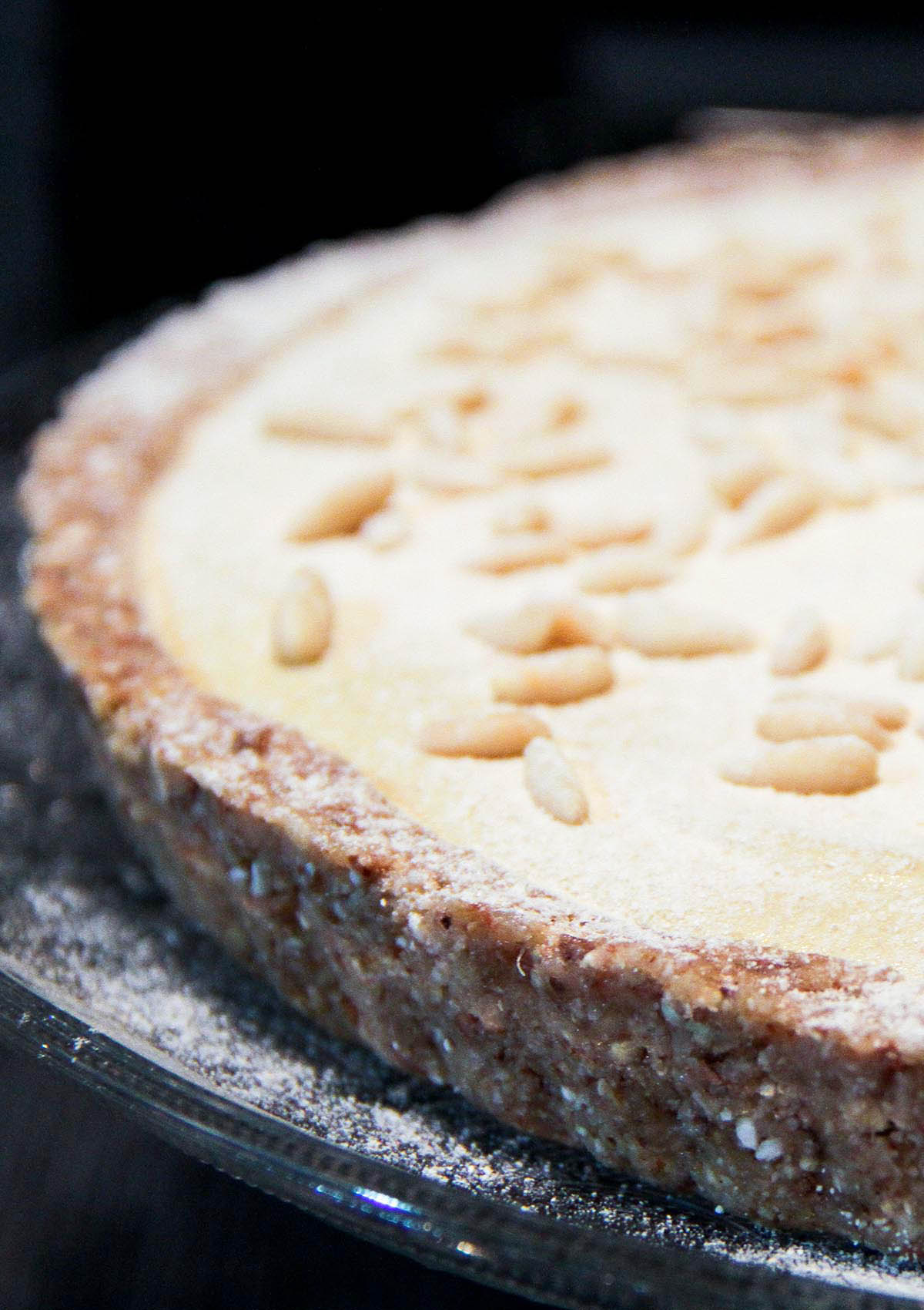 Torta della nonna Una sezione di torta con pinoli sopra e sfondo nero